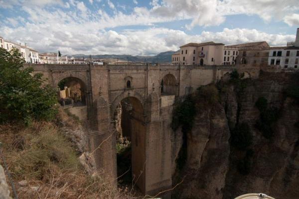 Steinerne Brücke über eine tiefe Schlucht mit Gebäuden links und rechts