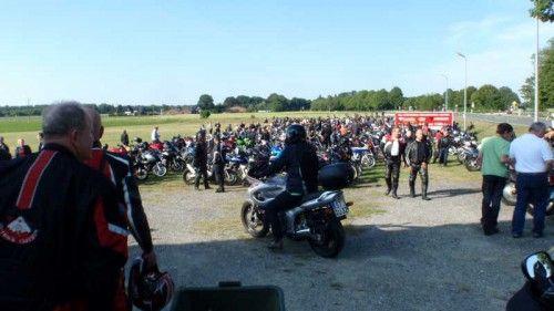 Viele Motorradfahrer und zahlreiche Motorräder auf einem Feldweg bei klarem Himmel