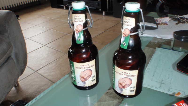 Zwei braune Bierflaschen mit Bügelverschluss auf einem Glastisch