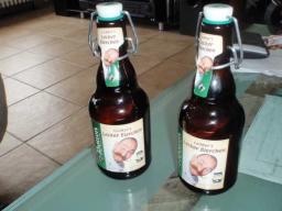 Zwei braune Bierflaschen mit Bügelverschluss auf einem Glastisch