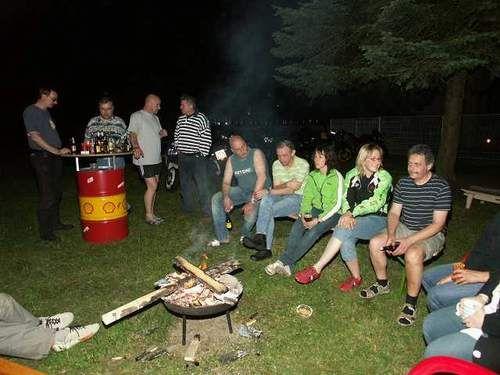 Gruppe von Menschen an einem Lagerfeuer im Freien bei Nacht