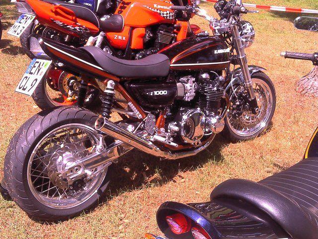 Schwarzes Kawasaki Motorrad parkt auf Grasfläche neben weiteren Motorrädern