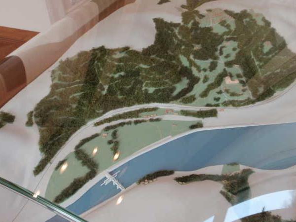 Modell einer Flusslandschaft mit Waldflächen und einer Brücke über den Fluss