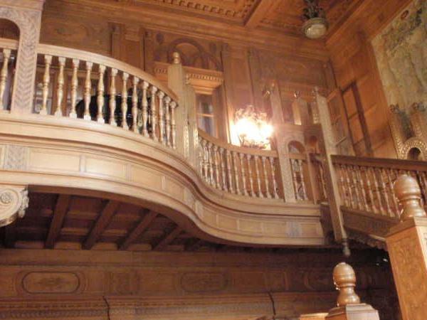 Aufwendig geschnitzter Holzbalustraden und Deckenverzierungen in einem historischen Gebäudeinneren